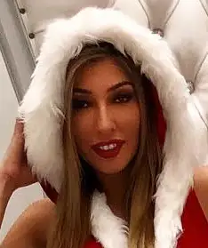 Bratty Nikki dressed as a drunken Mrs Santa Claus while seated in the iWantClips.com throne.